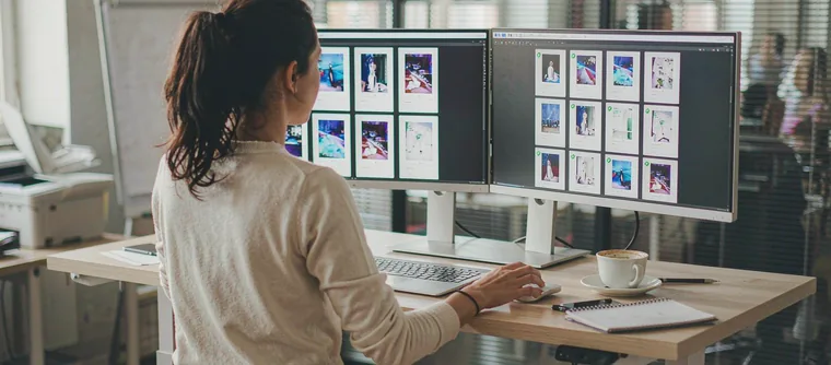 A performance marketer reviewing rows of vertical ad variants on two monitors